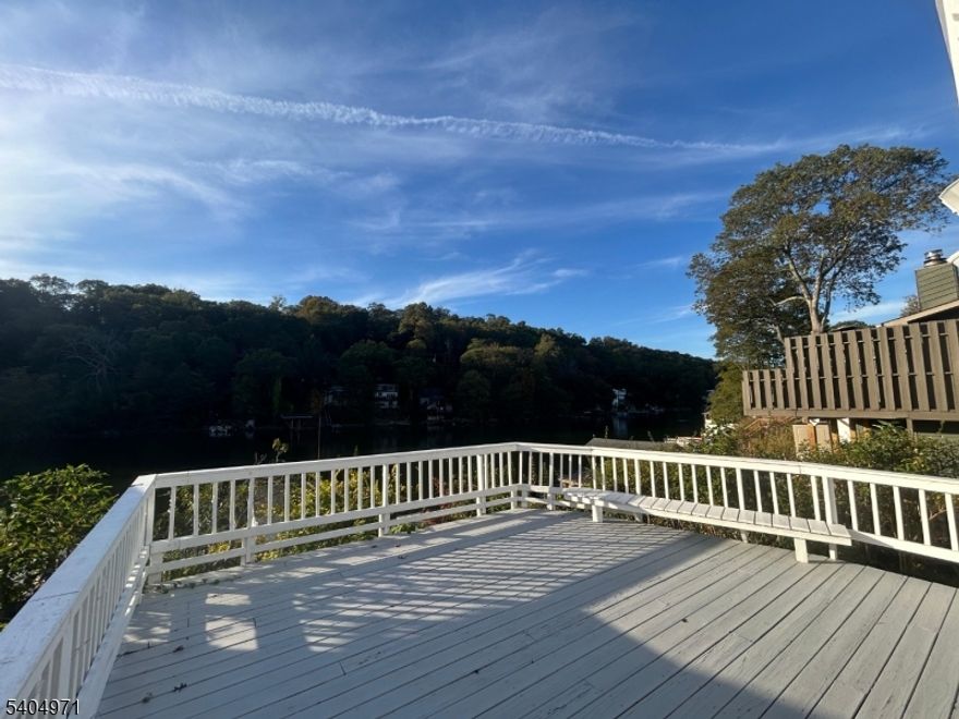 STUNNING LAKEFRONT HOME located on one of the calm/peaceful sections of the largest lake in NJ. This beautifully crafted home features 3 bedrooms and 2 full bathrooms, perfect for gatherings or a peaceful retreat. As you enter, you're welcomed by a warm and inviting living room with a wood-burning fireplace and glass sliding doors leading to the large balcony overlooking the lake. The 3 bedrooms and 1 full bath are conveniently located on the same floor. The kitchen, next to the second full bath, down the steps, has granite countertops, an eating area with views of the lake, and sliding doors leading to the very large deck. Venture down the exterior steps to discover a cozy patio area with a BOAT HOUSE, perfect for water enthusiasts to store watercraft and gear with the potential to build a deck on the roof for even better views! The house is heated by electric baseboards and air-conditioned by ductless mini splits. This home has a New well tank, pump and new sophisticated filtration system and PUBLIC/MINUCIPAL SEWER. 2 car driveway, laundry hookups, incredible views and minutes to major routes. Do not miss your chance to own this remarkable LAKEFRONT home - your dream getaway awaits! The property is vacant and ready for move in!