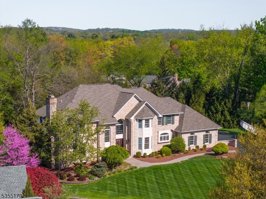 Set on nearly an acre on a cul-de-sac close to town, this beautifully appointed 5 bedroom, 5.1 bath, brick front colonial with 3-car garage and Tesla EV charger, has a finished walkout basement, and recently refinished hardwood flooring. The open first floor plan sets a perfect stage for entertaining with a soaring double height foyer, family room with floor-to-ceiling stone fireplace and a sunlit conservatory. The bright and airy kitchen showcases Taj Mahal quartzite countertops, center island and stainless steel appliances. In addition to an office/living room with gas fireplace and formal dining room, a convenient first-floor bedroom with adjacent full bath and a powder room complete this level. Bringing the outdoors in, the breakfast room opens to the screened porch with knotty pine beadboard vaulted ceiling and expansive deck, both of which provide beautiful views of the large, private yard. Upstairs, the spacious primary suite features a large and light-filled ensuite bath with soaking tub, double vanities, a large shower and three walk-in closets. Three additional bedrooms and two additional baths,  including an ensuite, complete this level. The finished, walk-out basement offers a spacious recreation room, game area, exercise room and a full bath. All this, plus top-rated schools, easy access to transportation, shopping, and dining. This home epitomizes the best of 21st century luxury living.