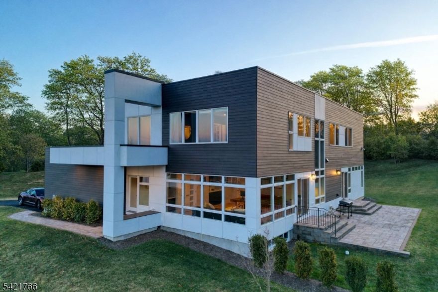 Discover true elegance in this custom-built modern home, completed in 2023, nestled on an oversized lot at the end of a tranquil cul-de-sac in the beautiful community of Parklane Estates. This architectural masterpiece greets you with an abundance of natural light through luxury Velux 9'x7' skylights that enhance the inviting atmosphere. The expansive open-concept kitchen and great room, featuring a premium Astria fireplace, stunning Anderson 400 series windows, and wine fridge, create an ideal setting for entertaining while showcasing breathtaking views of the surrounding landscape. Beautiful French oak wood flooring runs throughout, adding warmth. The thoughtfully designed first floor effortlessly integrates living and dining areas, including an exquisite half bath for guests. Ascend to the luxurious primary suite, complete with a spacious walk-in closet and a spa-like bathroom that boasts dual sinks and a custom shower. Benefit from an upgraded 13 SEER, 2-zone HVAC system and an advanced water heater for year-round comfort. The generous unfinished basement, featuring 9' ceilings and bathroom rough plumbing already in place, invites your vision to create a gym, guest suite, or vibrant recreational space.This residence also includes a 2-car garage equipped with an EV charging station and ample outdoor space for leisure and relaxation. Conveniently located near NY public transport and major highways, this home is a true haven.