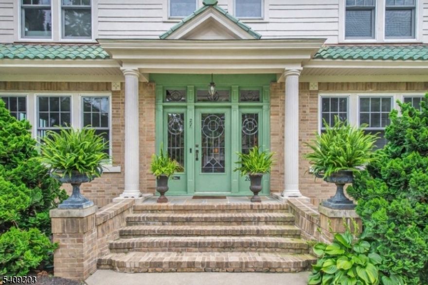 Impeccably updated 5 bedroom, 4.5 bath center-hall home on one of Glen Ridge's most coveted streets, blending timeless architecture with modern living. A Mediterranean-style tile roof and inviting vestibule with stained glass, chestnut detailing, and mosaic flooring set the tone. Inside, a gracious foyer with elevated ceilings and sweeping staircase leads to rich millwork and dark hardwood floors. Formal living and dining rooms are ideal for entertaining, while a sunlit solarium with built-ins works perfectly as a home office or retreat. The reimagined kitchen features quartz counters, custom white cabinetry, dual gas/electric ovens, and premium Samsung appliances. A nearby porch extends the living space, plus a stylish powder room. Upstairs, the primary suite offers a spa bath with radiant heated floors, soaking tub, and oversized shower. Generous second floor bedrooms include a private two-bedroom wing with full bath. The third floor adds a 5th bedroom, full bath, and spacious landing. The finished lower level includes radiant heat, laundry, cedar storage, a full bath, and ample storage. Outdoors, a fenced garden with bluestone patio and mature hydrangeas creates a peaceful retreat. Recent upgrades include a new furnace and hot water heater, whole house water softener, drinking water filtration system, plus a detached garage converted into a private gym with sauna. Convenient to NYC transportation, parks, the Glen Ridge Country Club, and top-rated schools.