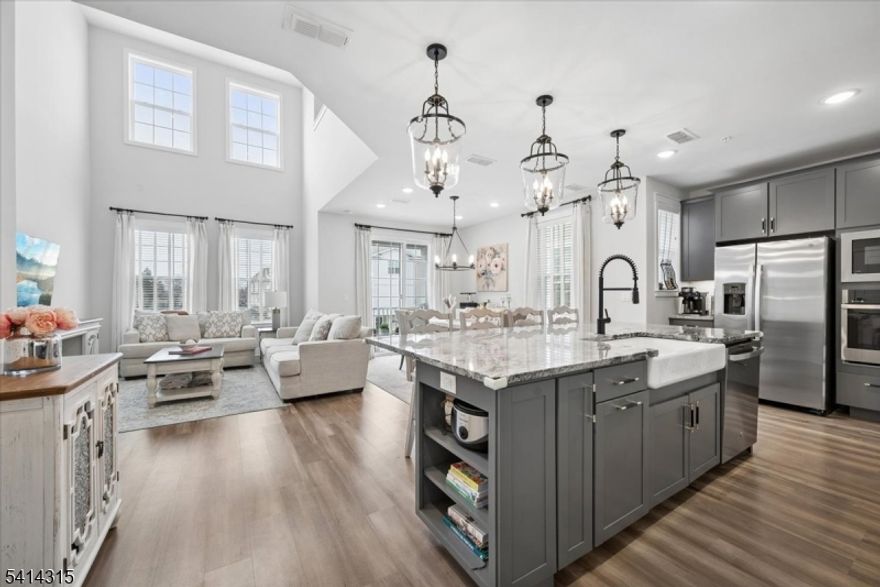 Welcome to "The Crossings at Dunellen,  a vibrant newer townhome community where modern design and upscale amenities meet effortless living. This beautifully appointed home offers contemporary style and everyday comfort, further enhanced by the significant financial benefit of a tax abatement through the PILOT program. The main level features a welcoming foyer with access from the front entrance and attached garage. Upstairs, the impressive open-concept living area is filled with natural light and soaring ceilings, creating a sophisticated atmosphere. At the heart of the home, the stunning kitchen features sleek cabinetry, granite countertops, and an oversized island overlooking the dramatic 2-story loft. Just beyond, the dining area opens to a private balcony, ideal for unwinding outdoors. The upper level is designed for comfort, featuring a serene primary suite with a walk-in closet and a beautifully finished en-suite bath. Two additional spacious bedrooms, a flexible bonus room for a home office, a versatile loft, and a convenient laundry room complete the space. Residents enjoy resort-style amenities including a clubhouse, gym, yoga studio, BBQ area, and outdoor pool. A true commuter's dream, it is situated just a couple of blocks from the Dunellen NJ Transit station and bus routes for a seamless NYC commute. Steps from Columbia Park's track, sports fields, and playground, with easy access to Route 22 and I-287, this property perfectly balances luxury and connectivity.