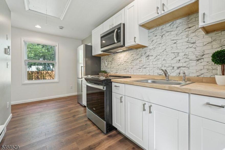 Welcome to your beautifully renovated 2-bedroom raised ranch, where comfort and charm come together in every detail. Step inside to a bright and airy space filled with natural light and stylish finishes. The gorgeous kitchen features classic white shaker cabinets and rich butcher block countertops perfect for cooking and gathering. You'll love the spacious full bath with sleek, modern fixtures, and the recessed lighting that adds a cozy glow throughout. Enjoy year-round comfort with ductless split AC units and beautiful wood laminate flooring that flows seamlessly from room to room. The inviting living room opens to a lovely deck through sliding glass doors, where you can take in breathtaking views of the river. Close to NYC transportation, shopping and restaurants. This is more than a home it's your own private paradise.