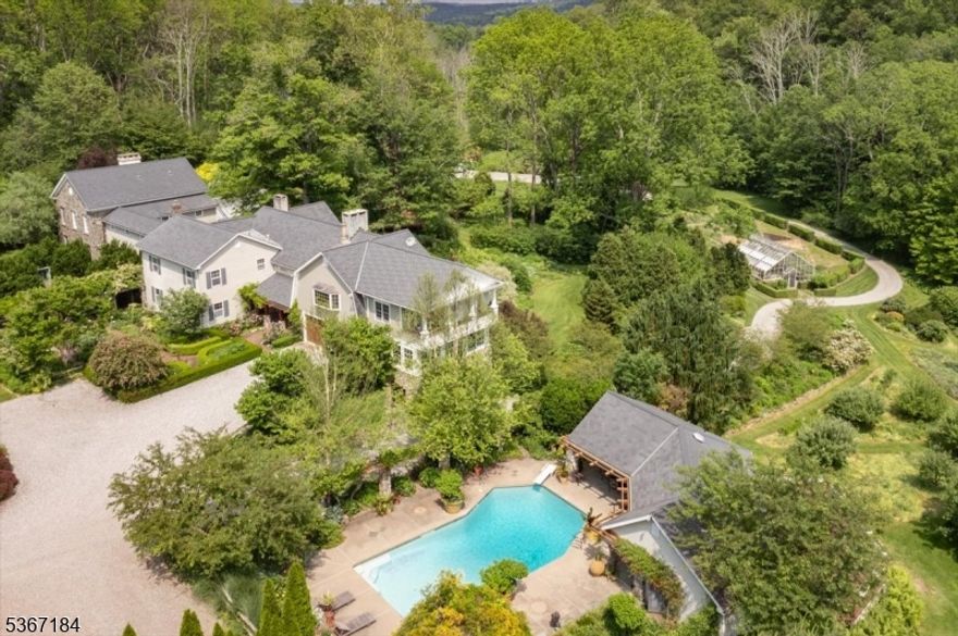 Set on over 40 private, wooded acres, 936 Dove Island Road is an awe-inspiring retreat with magazine-worthy organic gardens, private pond, and property features seen in numerous publications over the years. The Main Residence began as an old farmhouse and now hovers around 10,000 sf, featuring an expansive primary suite with dual dressing rooms, sitting room with fireplace, walk-in shower overlooking the grounds, and a spiral staircase to private solarium.  The airy two-story great room holds a massive stone fireplace, antique stained glass, and custom second story library that extends the room's length, surrounding the open kitchen with its beautiful Aga range. In addition, the home features a gallery + office wing with a transplanted 19th century Wall Street walnut-paneled boardroom, a long hall of museum-quality display cases, and attached greenhouse with koi pond. Additional buildings include the Iron Barn with climate controlled gallery + offices, drive-in storage, and 6 garage bays; the Staff Building with full kitchen, office, upstairs loft, diesel tank for utility equipment, and heated garage; the Utility Barn with over 1,100 sf for pallet storage, vehicles, and property maintenance; the Pool House with a heated gunite pool, full kitchen, and facilities; and finally the Lower Greenhouse for year-round cultivation + summer plant storage w/ drip irrigation system. All elements of the property are supported by a robust backup generator system.