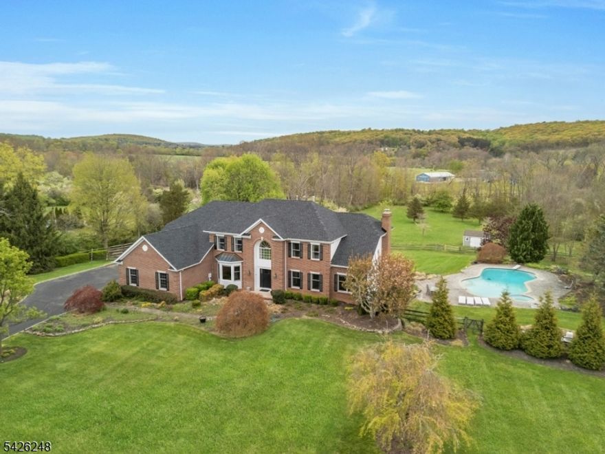 This beautiful home offers approximately 5+ acres of lush, landscaped property, offering ample space and a peaceful, scenic setting. The home features a welcoming entryway with hardwood floors that lead into the open-concept layout. The expansive living areas are filled with abundant natural light, creating a bright and airy atmosphere. The hardwood flooring extends throughout the main level, accentuated by an elegant staircase. The well-designed kitchen boasts high-end finishes and a spacious layout, ideal for those who enjoy cooking and entertaining. The primary bedroom suite includes a luxurious bathroom with an elegant tub and a spacious, luxurious shower. The other bedrooms are generously sized, offering ample space for rest and relaxation. All of the bathrooms have been updated. The home also offers a fifth bedroom on the first floor with adjacent full bathroom.  The roof was replaced in April 2026.  This home provides a spacious and well-appointed living experience, perfectly suited for a variety of needs and lifestyles. Home also has a portable generator hookup.