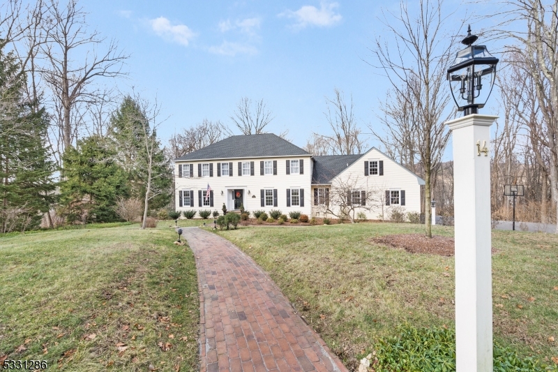 Picture perfect Center Hall Colonial set back majestically on a beautiful sidewalk neighborhood cul-de-sac in a coveted east Mendham Twp neighborhood. 12 rooms comprising 4 airy bedrooms including a cloistered primary bedroom suite, 2 full baths, 2 lovely renovated powder rooms, expansive living room that opens to a resplendent sunroom w walls of radiant windows, comfortable family room has a raised-hearth gas fireplace, exceptional newly renovated designer kitchen with gleaming quartz countertops, all stainless steel appliances, & roomy eat-in area surrounded by windows w easy access to rear deck, new butler's pantry is well-appointed & connects to the formal dining room, handsome home office, convenient service area w new mudroom, laundry room, powder room, & discreet back stairway to the 2nd floor front-to-back recreation/leisure room, plus elegant custom millwork, polished hardwood flooring, solid six-panel interior doors, neutral interior color scheme, and 8' ceilings throughout.  This 3,729 sq ft luxury home has a comfortable, easy living floor plan & seamless flow w the added utility of a sprawling full basement w handy walkout, plus a charming new front portico that welcomes you to an extra-wide and light-filled foyer, inviting multi-tier wood deck, 3-car attached garage, & paved driveway w ample parking. Breathtaking 2.23 acre showcase property replete w new landscaping, updated underground sprinkler system, updated night accent lighting, & surrounded by woodlands.