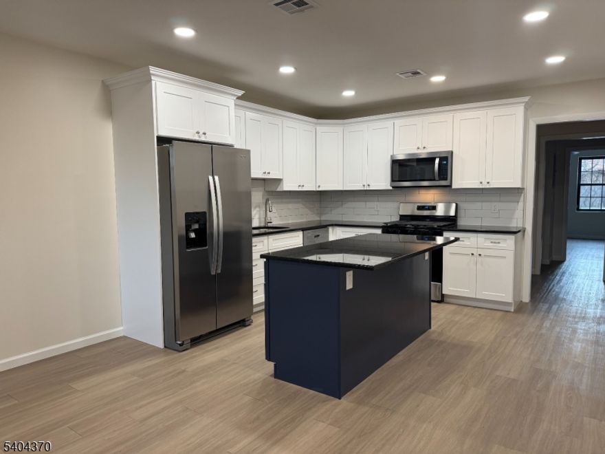 Welcome to this newly renovated side by side 2-family home located in the Silver Lake section of Belleville, NJ. This multifloor 3-bedroom, 2-bath apartment offers everything you need. Enjoy an open-concept kitchen with stainless steel appliances, granite countertops, and hardwood floors throughout. The unit includes in-unit laundry and access to a backyard. Please note: no driveway or parking included - on street parking. Features central A/C and forced hot air. Conveniently located near local shops, restaurants, and parks, with the Silver Lake Light Rail just down the block - access to Newark /New York Penn Station & other stops along the Hoboken, JC, Newark Airport, Etc. 1 pet under 25 lbs!!