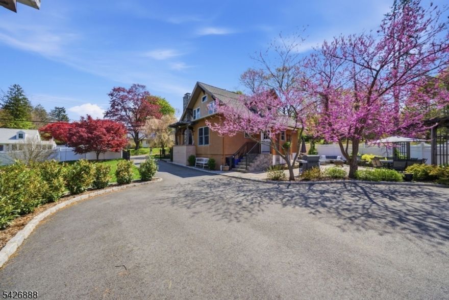 An exceptional custom home set on over a .25ac of private, beautifully landscaped property. This rare offering combines timeless architectural charm with modern updates, all supported by Randolph's rare & highly sought after public utilities, including water, sewer & natural gas. The fully fenced yard features a large gated driveway entrance, expansive lawn space & a stunning paver patio surrounded by gorgeous landscaping, creating a serene outdoor setting. A detached 3 car garage offers incredible versatility, plus full basement for addtl storage or workspace. The home showcases classic Craftsman details at every turn, including exposed woodwork, coffered ceilings, rich moldings, stone accents, built ins, solid wood doors & HW floors. A striking stone faced fireplace anchors the living space, adding warmth & character. The home has been thoughtfully updated to preserve its historic charm while incorporating modern conveniences. The layout provides flexibility for a variety of living needs. The updated eat in kitchen features radiant heated floors, blending comfort & functionality. The primary suite includes a sitting area & access to a private deck. Addtl highlights include a newer CA system (just 2 yrs old) & an overall level of craftsmanship rarely found today. A truly special home that offers character, space, & privacy while still being conveniently located near schools, shopping, dining, & major commuting routes. Lot next door is NOT included in this sale.