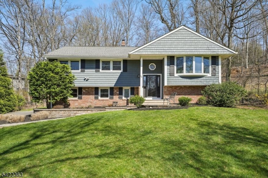 Welcome to this beautifully expanded bi-level home in the highly sought-after community of Berkeley Heights. Designed for both everyday living and effortless entertaining, this home offers a blend of comfort, style, and functionality. The main level showcases a bright, open-concept layout featuring a spacious living room, dining area, kitchen, and family room all flowing together with ease. At the heart of the home, the stunning kitchen boasts a center island with seating for 4, quartz countertops, stainless steel appliances, and a farmhouse sink. A dedicated coffee station with a wine/beverage fridge and built-in pantries adds both charm and everyday convenience. Just beyond, the expansive family room impresses with vaulted ceilings, oversized windows that flood the space with natural light, and a wood-burning fireplace. Sliding glass doors lead to a TREX deck that wraps the side and back of the home perfect for indoor-outdoor living. This level also offers 4 generously sized bedrooms, including the primary featuring a walk-in closet and ensuite bath with a separate stall shower and a jacuzzi tub. The lower level provides additional living space, including a 5th bedroom, a full bath, and large rec room ideal for guests, home office, or a play area, as well as garage access and a storage room. Set on a beautiful property, the outdoor space is equally inviting, featuring a dedicated fire pit area. A perfect blend of space, warmth, and modern updates this home truly has it all.