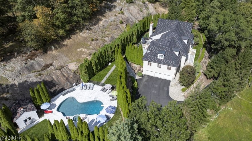 Discover an extraordinary estate featuring a FIRST FLOOR PRIMARY SUITE redefining luxury in Sparta's most coveted enclave situated in the highly sought-after Sawmill Estates neighborhood located just 1 HOUR TO NYC! Nestled on 3.71 acres, 49 Cherokee Court is a 7,600+ Square Foot residence blending classic grandeur with modern refinement. Upon entry you are greeted by a Soaring Two-Story Foyer grand entrance making a stunning first impression. The main level features a Cathedral Ceiling Living Room with overlooking balconies anchored by a stately Fireplace, a Family Room accented by ceiling wooden-beams, elegant Formal Dining Room & Formal Family Room/Office space. The gourmet Eat-In Kitchen is a Chef's delight highlighted by Top-Of-The-Line Appliances, custom-milled Cabinetry & Center Island with Breakfast Bar. The First Floor Primary Suite features a BONUS Adjoining Suite with cozy Fireplace, Walk-In Closet & En-Suite Bathroom including a Dual Vanity Sink, Stall Shower & jetted Soaking Tub. Upstairs you will find 5 spacious Bedrooms with 3 En-Suite Bathrooms completing the space. This Private Oasis getaway is an Entertainers Paradise offering a STUNNING Heated In-Ground Gunite Pool with built-in Hot Tub and gorgeous Marble hardscape surrounded by lush landscaping & a wooded backdrop. Sparta offers the #1 School District in Sussex County. Nearby highly desired attractions Lake Mohawk in Sparta, Lake Hopatcong & Year-Round Resorts Crystal Springs, Minerals & Mountain Creek.