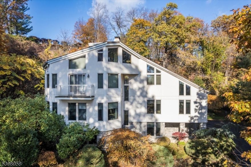 Don't miss this special contemporary home offering seasonal NYC views set on a secluded, private lot so close to vibrant Upper Montclair Village. Oversized windows and several skylights flood the home with natural light. The ground floor offers versatile living space with large rec room or guest suite with fireplace, full bath, gym, laundry and garage access. 1st floor offers an open floor plan with eat-in kitchen and family room leading out to an outdoor deck, incredible for entertaining or just relaxing; a formal dining room, large living room with stone fireplace and outdoor another deck, powder room, bedroom with ensuite bath. 2nd floor has 2 bedrooms, hall bath and the primary suite featuring a bath with double sinks, a spa-like tub, shower, make up counter, 2 walk-in closets and a gas-fireplace. Additionally, on the 3rd floor you'll find an office or den plus storage. Some notable updates and features include a high ceilings, whole house generator, roof and skylights replaced in 2019 , 3 zone central air, sprinkler system, dumb waiter from kitchen to garage and laundry chute. Close to Upper Montclair Village with restaurants, movie theatre, shops, supermarkets and NYC direct train.