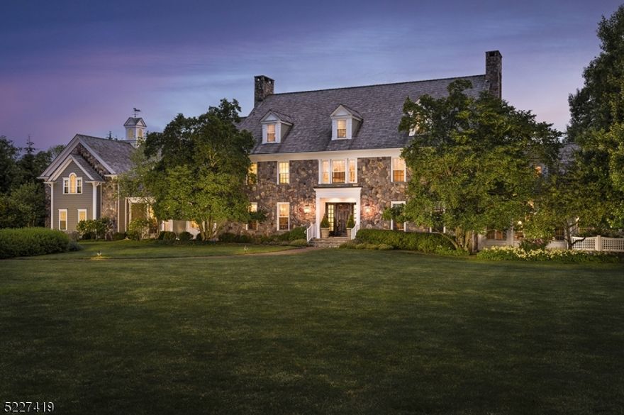 'Meadow View' - This stately fieldstone and clapboard Colonial is beautifully situated on seven acres of level, landscaped land in an established neighborhood of luxury homes.  The current homeowner commissioned a noted local architect to bring their vision for a country estate to life.  The end result is a timeless design that is destined to age with grace.  A cedar shake roof, fieldstone chimneys and a copper topped cupola complement the traditional Colonial architecture of the 25-room residence.  Fieldstone wall and white lattice fencing outline the formal cutting garden that adjoins the side lawn and can be viewed from the living room.  A gorgeous Gunite pool with spa and an illuminated Har-Tru tennis court offer resort style living in a private country estate setting.  Upon entering the home, the visual impact of a three-story foyer, along with the intricate millwork and moldings, set the stage for the abundance of architectural details and bespoke craftsmanship that are found throughout the home.  The floor plan encompasses over 9,500 square feet of living space with six en suite bedrooms, three fireplaces and the option of a seventh bedroom suite in what is now used as a billiards and media suite on the second floor.  In a forward-thinking design, the updated expansive kitchen is open to the breakfast area and continues to the family room.   Additional finished space is found in the lower level, which offers a recreation room, gym, game room and powder room.