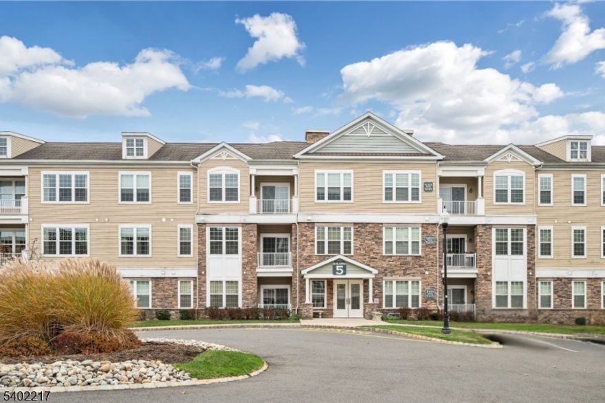 Welcome Home to one of the most desirable & rarely available floor plans in the community. Now featuring a standout upgrade that truly sets it apart: two deeded garage parking spaces, a rare & highly sought-after offering. This sunny & spacious home offers a 25-foot open living and dining area. The kitchen has a breakfast bar, stainless steel appliances, granite countertops, pantry, and a pass-through to the living area. The primary suite includes space for a sitting area, two walk-in closets, and a large ensuite bath with double granite vanity and walk-in shower. A generously sized second bedroom and full bath ideal for guests or a home office. Additional upgrades include tile backsplash, lighting, ceiling fans, and an abundance of windows that fill the home with natural light. Enjoy your morning coffee on the covered terrace overlooking peaceful views. This home is truly move-in ready and includes a storage unit. Located just a short walk to the stunning 16,000 sq ft clubhouse with resort-style amenities including an indoor pool, sauna, fitness center, aerobics/dance studio, game & card rooms, art studio, banquet space, & more. Outdoor amenities include a pool, picnic pavilion with gas grills, tennis & pickleball courts, walking paths, & a community garden, all in a park like setting with a vibrant social calendar. Ideally located near shopping, dining, major highways, NYC transportation, golf, & parks. This home offers the perfect blend of luxury, convenience, & lifestyle.