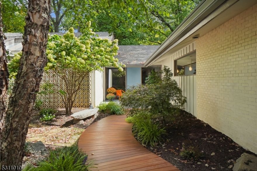 Experience this exquisite, light filled, Mid-Century Modern masterpiece in the sought-after Yantacaw Brook section of Upper Montclair. Built in 1960 by acclaimed architect Milton Klein, this home is a true gem with its impeccable millwork, soaring floor-to-ceiling windows, and thoughtfully designed spaces. Featuring four spacious bedrooms, a versatile office, and a sunken living room adorned with retro shag carpeting and travertine backdrop, this residence seamlessly blends 1960's "Mad Men" glam with modern functionality. Entertain guests in the elegant dining room or enjoy a casual meal at the breakfast bar in the open kitchen. Sip your morning coffee on the deck off the primary suite overlooking lush gardens, then head to the primary bath with radiant floors and a sunken shower. If fresh air is what you crave, step outside the primary bath into the luxurious outdoor shower! If you're not already in awe, wait until you see the indoor swimming pool, which opens onto a stunning bluestone patio ideal for entertaining. Custom benches, a remote-controlled pergola and built-in gas fire pit make this the go-to house for parties big and small. The expansive wrap-around yard, with lush, Japanese-style gardens, offers a serene retreat and direct access to the tranquil Tuers Park. This is a unique opportunity to own a piece of architectural history in one of Montclair's most desirable areas. This home has been the backdrop for numerous fashion editorials and commercial shoots.