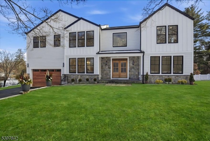 Welcome to an absolute gem of a luxury home, perfectly tucked away on a quiet cul-de-sac yet just steps from schools, sidewalks to town, and everything this vibrant community offers. Fully rebuilt and spanning 4 beautifully finished levels, this stunning residence features 6 spacious bedrooms and 6.5 thoughtfully designed baths, offering remarkable space and livability. Bathed in natural light from abundant windows and enhanced by soaring 9 ft ceilings, the home sparkles with warmth and elegance at every turn. Meticulous craftsmanship, custom millwork, and high-end finishes reflect a commitment to quality throughout. A first-floor en suite provides ideal accommodations for guests. At the heart of the home is a chef's kitchen, equipped with top-tier designer appliances and an oversized island that invites gathering and connection. Entertain effortlessly in the formal dining room with its chic butler's pantry. The primary suite is a serene retreat, boasting a spa-like bath with double shower, dual vanities, and his-and-hers walk-in closet space. 5 additional generously sized bedrooms and ample baths ensure comfort for all. The finished walk-out basement offers exceptional flex space, a full bath, and access to a private, level backyard with a patio and tranquil wooded views.  With easy NYC access, an unbeatable community, and extraordinary space filled with light, this home truly offers the best of inspired luxury living. This exceptional home is complete and move-in ready.