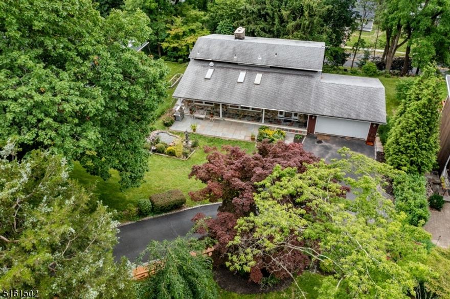 Prepare to fall in love with this appointed custom home sitting on a lush 0.5 acre in the  heart of Millburn! Unbeatable LOCATION. Steps to NYC Direct Millburn Station, Schools, downtown shops, restaurants, & park!  The acclaimed South Mountain trails are just a short walk way! 4 bedroom, 3 full bath, amazing natural light, high vaulted ceilings, deck with beautiful views, and a terrific open floor plan. Living Room features a stone fireplace and the fireplace is shared by the next door primary bedroom. Master bedroom features a sitting room and a spa-like bath and walks out to a fabulous deck overlooking nature's beauties. Home features two more double-vanity-bathrooms, three more bedrooms all with floor-to-ceiling windows and great nature view, and ample closet space, as well as an office, recreation room and laundry room. Attached 2-car garage and well landscaped grounds! Ideal location just a short walk to the Millburn schools, train station & great restaurants & shopping in downtown Millburn. And great low taxes! Not to be missed!