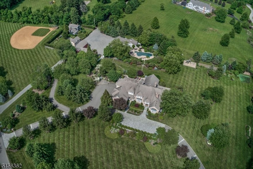 GAME ON!  Pickle ball anyone? Newly installed in the sports building. Four season activity for all ages and the sports enthusiast. Nine-flat-level-acre compound, beautifully landscaped, includes heated and air-conditioned outbuilding with workout room, basketball court, pickle ball, and batting cage for baseball, soccer or lacrosse practice.  Outdoor tee boxes and putting green, Bocci court, plus a regulation size irrigated baseball/softball field. Inviting salt-water heated pool with waterfall and spa. Amazing pool house with kitchenette, full bath, washer & dryer, locker, sauna and TV rooms and outdoor kitchen. The  14-room custom built home with 6 bedrooms, 6 full and 1 half baths and 4 car attached garage, is the centerpiece of this vintage estate setting with outbuildings including barns, garages, storage building, silo, 7 room cottage/office, and Koi-pond. Country quality of life with quick access to transportation modes. Perfect for today's flexible home and work lifestyle, high value and LOW taxes.  Outbuildings sold As Is, not known defects.
