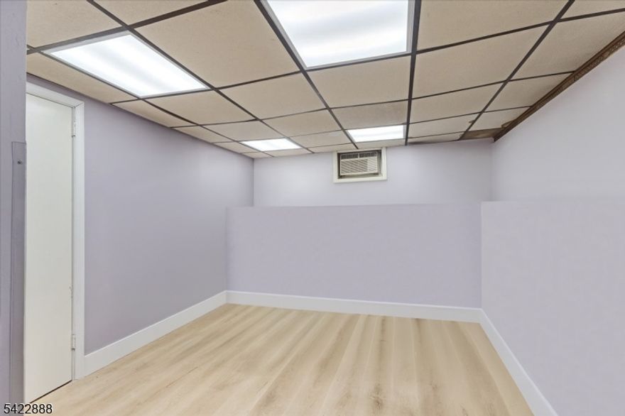 Commercial-Zoned Double Lot with Massive Parking & Flexible Living " Prime Elizabeth LocationRare opportunity to own a commercially zoned double-lot property offering exceptional flexibility for residential, business, or mixed-use purposes. This unique property features an expansive footprint and parking for 8"10 vehicles, making it ideal for contractors, business owners, or multi-vehicle households.The home offers 3 bedrooms and 1.5+ baths with additional potential living space. The main level features an open living and dining area with classic column detailing, flowing into a semi-open kitchen layout. Upstairs includes three well-sized bedrooms and a full bath.The recently renovated basement (completed about a month ago) is designed as an entertainment space with a bar/lounge area, updated finishes, an additional room, and a bathroom with plumbing already in place for further customization. The attic includes multiple partitioned rooms, providing flexible space for storage, workspace, or future reconfiguration.A standout feature is the full handicap-accessible design, including a permanent concrete ramp and motorized stair lift system, a rare and valuable addition.Ideally located 20 minutes from NYC transit, near Newark Airport, major highways, and within walking distance to supermarkets and retail, this property offers strong convenience and long-term investment potential in one of Elizabeth's most accessible locations.