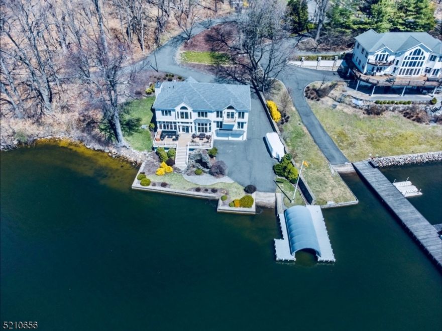 This luxurious 5 Bed 4.5 Bath custom Lakefront home on a spectacular lot on "Great Cove" at Lake Hopatcong! From the moment you arrive at this fabulous home site you will admire the stately architectural design of the home. Upon entering the welcoming Foyer the spectacular panoramic views of the lake before you will simply take your breath away! With over 3500 SQ Feet, the expansive open Floor Plan of this stunning home is well-designed and perfect for grand-scale entertaining and living! Impressive property features include floor to ceiling windows showcasing the lake views, gleaming hardwood flooring with inlay designs, recessed lighting, architectural columns, beautiful custom mural, a wood-burning fireplace insert with elegant mantle and designs, new generator... and the list goes on and on! As amazing as the interior of this home is, once you step outside onto the oversized Trex deck and take in the exquisite setting, you realize this is the epitome of Lakefront luxury living and will absolutely fall in love! Imagine calling this outdoor oasis your own! The amenities and recreational opportunities abound with its covered boat dock with new bumpers and cleats, a private launch, 4-Bedroom septic and the ideal location for deep water swimming, boating, water sports, entertaining and relaxing while enjoying the breathtaking sunsets. The Lake Hopatcong Yacht Club is where the annual area fireworks are hosted- relax and enjoy the spectacular views right from the back deck!
