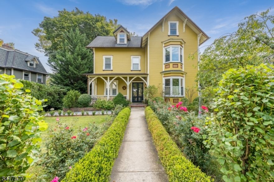Beautifully restored Victorian on a .68-acre lot blending timeless charm with modern updates just minutes away from the South Orange train station. The gracious Entry Foyer features original double wood-and-glass doors, hardwood staircase with original newel post, detailed moldings, and a mudroom nook. The Living Room offers French doors with transom, gas fireplace with original mantle, recessed lighting, and a bay window. The formal Dining Room includes a second gas fireplace with original mantle, built-ins, bay window, additional front windows, and ceiling medallion with chandelier. The Kitchen showcases commercial stainless appliances including a 6-burner Electrolux gas range, custom black cabinetry with glass uppers, butcher block counters, Spanish-style tile backsplash, and farmhouse sink in island, open to the Family Room with gas fireplace and French sliders to a pergola-covered deck. A main-level Full Bath adds flexibility. Upstairs offers three spacious bedrooms and a recently renovated hall bath with double vanity and frameless glass tub/shower. The newly finished third level provides two additional bedrooms, office/flex space, and a full bath with walk-in shower. Unfinished walk-out lower level with laundry, half bath, storage, wine fridge and freezer included. Restored exterior, fenced yard, pergola patio, Victorian-style carport, and central air complete this special home.