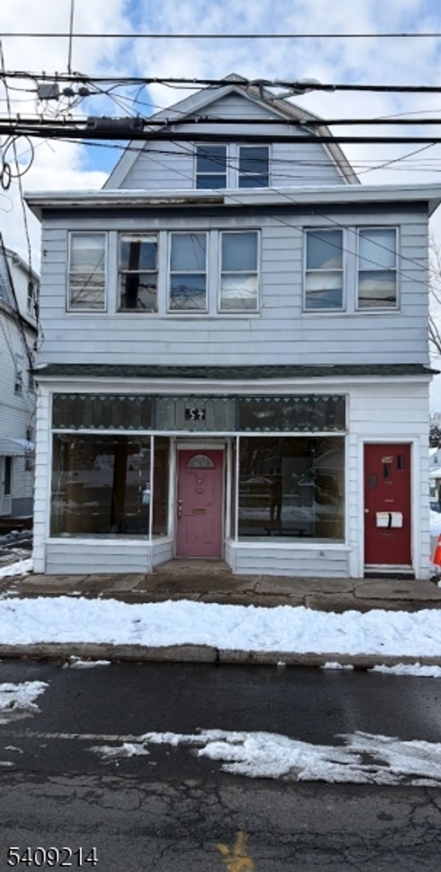 This property needs complete rehab presenting great possibilities for investors and owner occupied with 2 apartments and a store front for bus or office. Large lot-2car garage and ample parking.  Ground floor store front with powder room. 3rd floor with 2 bedrooms and heat.  Must see to realize full potential.