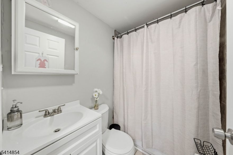 Welcome to this rare mother-daughter style Colonial situated on a double lot in the highly desirable Netherwood Heights neighborhood. Partly refreshed in 2025, this exceptionally spacious home provides flexible living arrangements across four distinct levels, making it a fantastic opportunity for various living situations. Come in from the classic open front porch to the first level, which shines with sleek flooring and a gorgeous modernized kitchen boasting crisp white cabinetry, and a lovely peninsula. This bright space flows effortlessly into a sunlit dining area and a living room, complemented by two well-proportioned bedrooms, a bonus room to suit your needs, and a full bathroom. Upstairs, the second level features a cozy second living room, an additional dedicated kitchen, two more bedrooms, and another full bathroom. The finished attic is a fantastic bonus, complete with its own full bathroom, making it appropriately set up for a private primary suite or retreat, making it the floor's third bedroom. Downstairs, the finished basement expands your options with a full bathroom, a generous recreation space that currently highlights its potential for a home studio or gym, and an additional room. Outside, enjoy a remarkably deep driveway for ample parking, a sprawling backyard ready for summer gatherings, and eco-friendly solar panels. Conveniently located just blocks from the Netherwood Train Station and the bustling shops along South Ave!