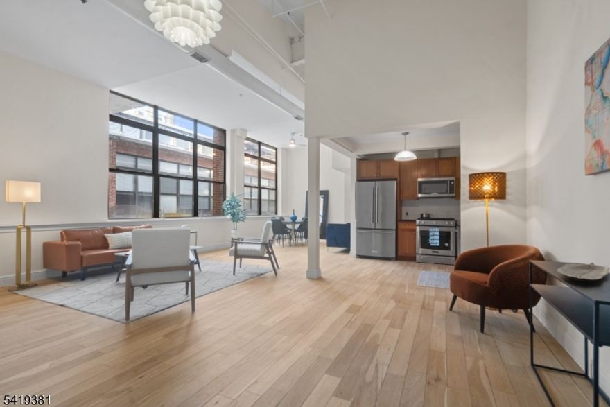 Dramatic and expansive industrial DUPLEX condo at the Foundry Lofts. This impressive home offers 2 bedrooms, 2 full bathrooms, and an open floor plan, ideal for entertaining. From the moment you enter, you?ll be captivated by the 16-foot ceilings and 7 oversized windows, which flood the home with natural light. The open and oversized layout features hardwood floors throughout, creating a seamless flow between the kitchen, living, and dining areas. The first level includes a bedroom, a newly updated full bathroom, a kitchen, an open-concept living/dining area, and a convenient laundry closet. Upstairs, you?ll find the primary bedroom, a walk-in closet, and another newly updated full bathroom. Additional highlights include central heating and cooling, three newly installed ceiling fans, and an in-unit washer and dryer for everyday convenience. The condo also comes with an assigned parking spot in a secure lot, making city living easy. Residents of the Foundry Lofts enjoy access to a common outdoor garden, a 24-hour desk attendant, a fully equipped gym, and an on-site bike room. Ideally located near local coffee shops, dining, Liberty State Park, and the Liberty Science Center Light Rail station, just one block away. This home offers an exceptional opportunity to enjoy the best of Jersey City!