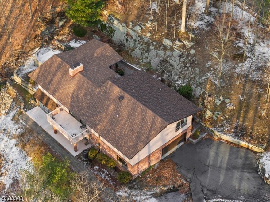 Don't miss this impressive 4-bedroom, 3-full bath Raised Ranch situated in the prestigious Smoke Rise gated community, one of New Jersey's premier lake enclaves. This home offers an unparalleled lifestyle with access to a private lake, sandy beach, boating, fishing, tennis/pickleball, and fine dining at the historic Smoke Rise Inn all protected by 24-hour security and located just 35 miles from NYC.The main level features an inviting, spacious living room with gleaming hardwood floors, a cozy wood-burning fireplace, and sliders leading to a deck that offers serene winter views of the lake. The bright, sun-filled eat-in kitchen is equipped with a center island, Corian countertops, and newer stainless steel appliances.  There is a separate dining room for more formal dining or holidays. The primary suite serves as a private retreat with a walk-in closet and en-suite bath, complemented by two additional bedrooms and a full guest bath.The versatile lower level expands your living space significantly, boasting a large great room with a second fireplace and sliders to a covered patio. This level also includes a 4th bedroom, full bath, laundry room, and a private sauna perfect for relaxation. Close to major highways, public transportation, golf courses, and hiking trails. Experience luxury and nature in perfect harmony.