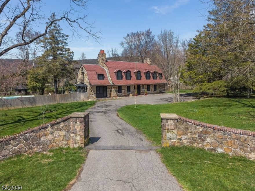 Stunning custom country estate with 2 homes on over 4 acres completely surrounded by 60 acres of protected conservation land. This one-of-a-kind property built with stone from the Morris Canal and constructed by masons from Italy! Each home has been completely renovated & restored & showcases remarkable attention to detail, blending historic charm with modern efficiency throughout. The main residence features an extraordinary red slate roof & a beautiful in-ground pool, offering timeless elegance & exceptional privacy. It also features 4 spacious bedrooms, 4 full baths & 2 half baths, highlighted by exquisite woodwork, wainscoting, & detailed moldings. Sun-filled, generously sized rooms & beautiful hardwood floors create a warm &  inviting atmosphere. The expansive primary suite is a true retreat, offering a sitting area, cozy fireplace, & a luxurious marble bath. Designed for both everyday living & casual entertaining, the home also includes fireplaces in the living room and kitchen. Stately stone entrances and a circular driveway provide impressive curb appeal along with ample parking in addition to a 2 car garage behind the house. A separate cottage enhances the property, complete with 3 more garages, 2 bedrooms, living room, eat-in kitchen & full bath perfect for extended stays & guests. Whole house generator.  The property sits next to a small stream bordered by massive granite garden walls. The tranquility & beauty will leave you recharged & refreshed!