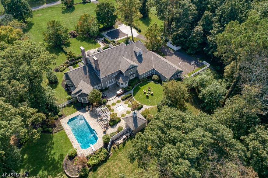 Gorgeous custom home impeccably positioned on 13 acres in sought after Far Hills.  Professionally landscaped with formal entry gardens, landscape lighting and deer fencing. Paver block guest motor court. Front bluestone courtyard, walkways and porch. In-ground pool with bluestone decking, hot tub, and stone-walled pool house with cupola, cedar lined changing rooms and storage area.  An exceptional, renovated gourmet kitchen opens to the family room with wood-burning fireplace and French door access to the rear patios. First floor primary bedroom suite with gas fireplace, newly expanded walk-in closets, and a spacious bath with patio access.  First floor apartment guest-suite with sitting room, kitchenette, bedroom, full bath and separate entrance.  First floor office and expansive exercise room. Second floor game room. Multi-zoned, natural gas fired radiant heating throughout. Crestron home automation system wired for HVAC, lighting & audio. Over-sized four car garage with vaulted ceilings and regulation basketball hoop. Newly installed natural gas generator.  Farmland assessed/low taxes.
