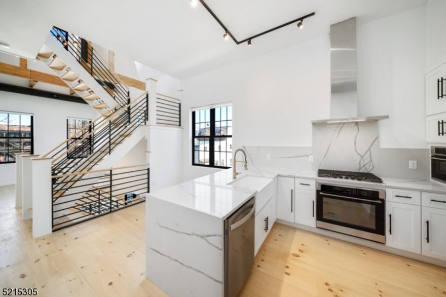 Introducing The Washington - a unique townhouse development in the heart of downtown Montclair. This modern loft-style 1/2 duplex consists of 4 levels including a finished basement and is flooded with natural light throughout. There are 3 bedrooms throughout the unit, each located on a separate floor (see floor plan) and having their own en-suite bathroom with standing shower and custom walk-in closet. The second floor provides an open concept living space with dramatic 20ft ceilings in the living room and 15ft ceilings in the kitchen/dining area along with a convenient half bathroom for guests. The kitchen boasts gorgeous stone counter-tops, a breakfast bar with waterfall feature & stainless steel appliances. A flex space upon entering the home can be used as home office, family room, play space or gym. The lower level provides storage, laundry & an egress window in the bedroom suite that's located on this level. Keyless entry and central air/forced hot air thermostat on every floor which can all be controlled from your smartphone. Enjoy a rooftop terrace with seasonal views of NYC and all of downtown Montclair. Steps away from Bay Street train station (NY direct line), boutique shops and countless eateries.