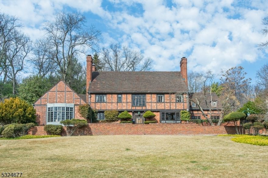 Magnificent architectural gem picturesquely situated on 1.70 acres of well- maintained exquisitely cultivated grounds with views of Manhattan. This custom built English Manor Home in the Mountain District of Montclair, was designed by the architectural firm of Harvey Stevenson, Eastman Studds, the construction was completed in 1933.  Lovingly constructed with artisan detailing, the manor is replete with stunning period details imported from England in 1929.  Lavish wood paneling, spectacular leaded windows, hand carved newel post and stairway, intricately carved fireplace overmantel, enriched plaster ceilings with tracery, hardwood flooring and one of a kind solid wood doors throughout. The Great Room is a wonderful example of Montclair's finest high-style architecture with a stately baronial fireplace and oriel windows that overlook the NYC skyline.  French doors in rear of the Great Room open to a private landscaped sanctuary.  With an oversized updated kitchen with Thermador appliances, breakfast room, den with fireplace, first floor office, expansive dining room, large foyer, five bedrooms and 5.2 baths this gracious home is well suited for entertaining.The custom grand staircase and Great Room windows were imported from England along with the exterior gutters. There are English historical themes on the exterior concrete and gutters.  This property boasts a swimming pool/hot tub, badminton/croquet court and a 3 car heated garage.  The grounds are watered by private well.