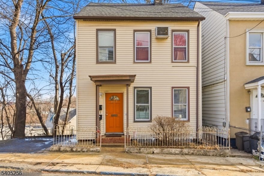 Two-family property located at 282 N 4th Street in Paterson featuring two 2-bedroom, 1-bath units. The ground-floor unit has been updated and includes a patio, while the second-floor unit offers a deck for outdoor space. Additional features include a large unfinished attic, an unfinished basement suitable for storage, and side driveway parking. Suitable for both investors and owner-occupants with rental income potential. Convenient location near local amenities and transportation.