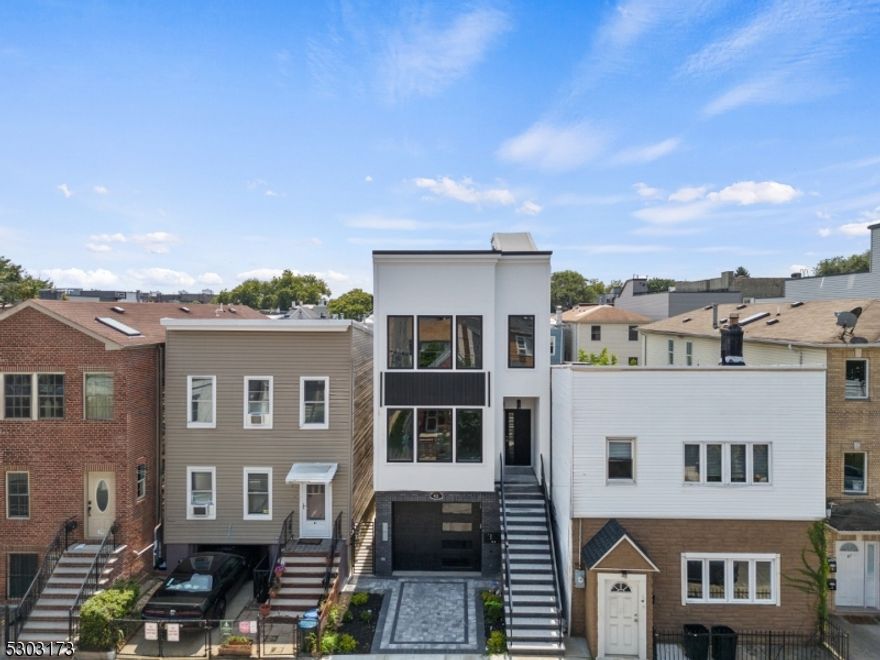 A striking opportunity to own this luxurious 2-Family property an impressive ground-up brand new construction in Jersey City Heights! Live in one unit and AirBnb the other unit for a MASSIVE INCOME! or rent out both units for a huge monthly rental. Total of 6br & 5ba. Both units feature a spacious living room with an elegant geometric accent wall & electric fireplace, large windows that flood the space with natural light, and hardwood flooring throughout the entire home. Modern kitchen with sleek white cabinetry, calcutta quartz countertops, minimalist backsplash, kitchen island and state-of-the-art stainless steel appliances, including Wine Fridge! Bedrooms have great size windows for bright space and ample closet space. Primary bedrooms feature warm wooden accents, an elegant en suite bathroom with glass-enclosed shower, generous sized walk-in closet and direct access to your own private balcony. Unit 1 has an exclusive access to the backyard and Unit 2 has its own private full size rooftop deck. 2 cars can fit in the garage, tandem-shared parking. Enjoy the vibrant community and nearby amenities, including Washington Park for leisurely moments. Shops, bars and restaurants are within easy reach, perfect for socializing and dining. Schools are conveniently close, and seamless transportation to NYC awaits you're just minutes away from bus stops and train stations. Don't miss out on this exceptional chance to invest and own a remarkable property! *virtually staged photos