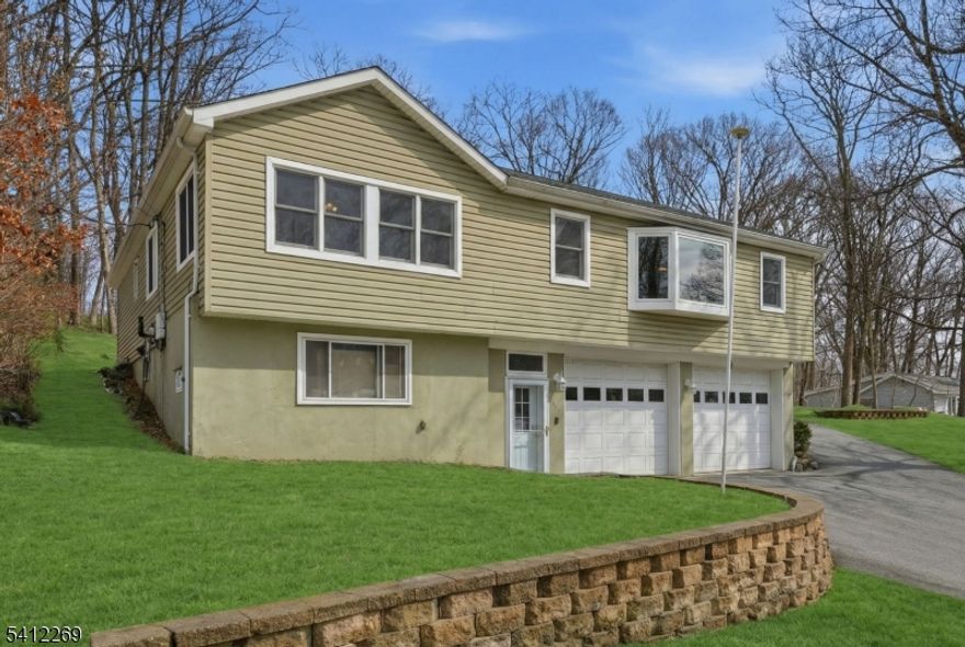 Experience this MASSIVE Raised Ranch home highlighted by a HUGE Oversized Heated Garage and 12+ Car Driveway perfect for any Motorhead, Craftsman or Hobbyist  located within minutes of highly-sought after Lake Hopatcong, New Jersey's Largest Lake & only 1 hour from NYC! This sprawling 3 Bedroom, 2.5 Bathroom home blends ample living space, large Bedrooms & Modern updates. Enjoy a spacious Living Room with Bay Window showered with natural light, gorgeous Hardwood Floors, an updated Eat-In Kitchen with High Ceilings, a Skylight & Breakfast Bar, and a Formal Dining Room. The Backyard offers TONS of hang out space, a private Deck, a Storage Shed & BONUS Additional Driveway parking making this home an Entertainers Dream! $65,000 of recent upgrades include 2 newly renovated bathrooms (2023), new furnace convertible to gas (2021), a MiniSplit AC system (2024), and a top of the line whole house water filtration system and water softener (2022). Commuters hub with easy access to major highways Rt 80, Rt 46 & Rt 10. Lake Hopatcong offers unlimited amenities including boating, fishing, swimming, beaches, waterfront dining, hiking, nearby a Ski Resort, top-rated Golf Courses and much more!