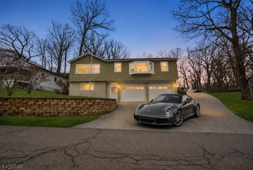 Experience this MASSIVE Raised Ranch home highlighted by a HUGE Oversized Heated Garage and 12+ Car Driveway perfect for any Motorhead, Craftsman or Hobbyist  located within minutes of highly-sought after Lake Hopatcong, New Jersey's Largest Lake & only 1 hour from NYC! This sprawling 3 Bedroom, 2.5 Bathroom home blends ample living space, large Bedrooms & Modern updates. Enjoy a spacious Living Room with Bay Window showered with natural light, gorgeous Hardwood Floors, an updated Eat-In Kitchen with High Ceilings, a Skylight & Breakfast Bar, and a Formal Dining Room. The Backyard offers TONS of hang out space, a private Deck, a Storage Shed & BONUS Additional Driveway parking making this home an Entertainers Dream! $65,000 of recent upgrades include 2 newly renovated bathrooms (2023), new furnace convertible to gas (2021), a MiniSplit AC system (2024), and a top of the line whole house water filtration system and water softener (2022). Commuters hub with easy access to major highways Rt 80, Rt 46 & Rt 10. Lake Hopatcong offers unlimited amenities including boating, fishing, swimming, beaches, waterfront dining, hiking, nearby a Ski Resort, top-rated Golf Courses and much more!