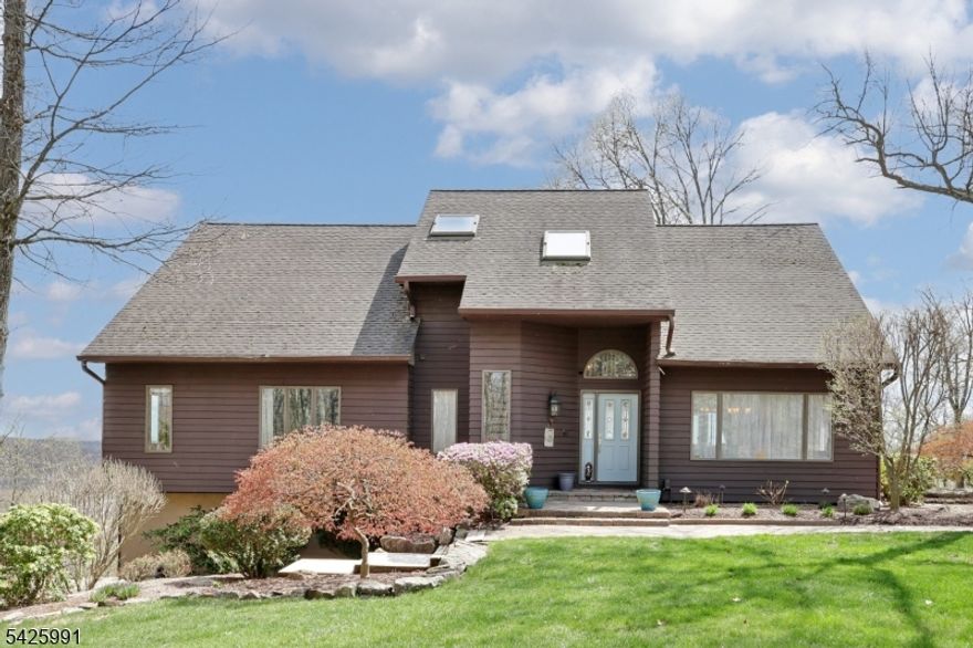 Perched on over two private acres in one of Rockaway Township's most scenic settings, this exceptional estate offers a rare blend of space, versatility, and breathtaking panoramic views stretching to the NYC skyline. Designed for those who value privacy without sacrificing convenience, this one-of-a-kind property delivers a lifestyle unmatched in the local market. The expansive residence features generously sized living spaces, multiple work-from-home options, and a flexible layout ideal for modern living. A separate dwelling suite provides the perfect solution for extended living, guest accommodations, or private office use. For hobbyists and automotive enthusiasts, the attached oversized garage is equipped with a car lift and workshop capability, while the impressive two-story barn/outbuilding offers exceptional space for storage or creative pursuits. Equestrian enthusiasts will appreciate the established paddock and barn, offering the opportunity to revive a private equestrian lifestyle. Bordering protected state land, the property provides rare, direct access to hiking, hunting, fishing, and year-round outdoor recreation. The grounds create a true private retreat peaceful and secluded, yet convenient to major commuting routes. A rare opportunity to own a distinctive estate where privacy, views, and lifestyle converge just a short distance from NYC.