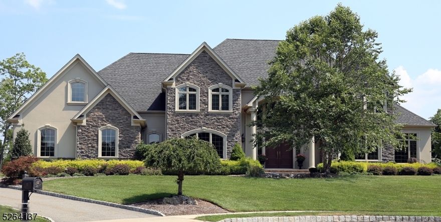 Exquisite custom stone Colonial nestled in a unique setting, offering unparalleled panoramic views for the most discerning buyer. Situated within a youthful subdivision, yet shrouded in complete seclusion, this residence is a harmonious blend of sophisticated craftsmanship culminating in a true masterpiece. The interior boasts top-of-the-line flooring featuring inlaid hardwoods, luxurious marble, and exquisite porcelain tiles. Custom molding graces every corner, elevating the home's aesthetic appeal. The gourmet kitchen is a culinary haven, showcasing handcrafted cabinetry, granite countertops, Wolf professional range, and high-end appliances. A sunken great room, adorned with walls of windows, sets the stage for a warm ambiance, complemented by a gas-ignited wood-burning fireplace. The private conservatory, strategically positioned, offers serene views and a picturesque setting. The primary bedroom suite is a sanctuary of luxury, featuring a lavish bath with private views, a cozy fireplace and access to a turreted balcony. A generously sized walk-in closet and dressing room adds to the opulence. Four additional spacious bedrooms, one on the main level with a full bath, provide ample accommodation. The large basement, with extra-high ceilings, is a canvas ready to be transformed. The oversized three car garage has a high efficiency Tesla charger. This residence is a testament to unparalleled elegance, where timeless design meets modern convenience.