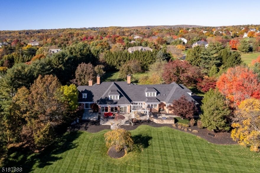 Just completed improvements throughout this sophisticated, all brick French Provincial elevate the interior to stylish new heights, but the sweeping view of Bedens Brook Club's 3rd hole remains the home's undeniable crown jewel. Step through the stunning foyer, with a glimmering chandelier overhead and gleaming tile underfoot, and continue to the great room, where an expansive wall of glass frames the stone patio, tree-dotted yard and rolling green golf course beyond. This central space features a brand new bar with waterfall-edge quartz and gray-washed cabinets concealing multiple wine fridges. New wood flooring extends into the openly combined kitchen/family room, where Fisher Paykel dishwasher drawers coordinate with appliances by Sub-Zero and Wolf and a massive U-shaped island faces the stone fireplace wall. A new, fully-tiled powder room is ready for guests and anyone working from home in the wood-paneled library. Also found in this quieter wing of the main level is the primary suite loaded with special details, like a coffered ceiling, custom closets and new bathroom vanities. Three upper level bedroom suites are just as large and comfortable with brand new, plush carpeting, which also blankets a shared bonus room. Nearly every room in this house is freshly painted, including the expansive basement, where a media room and barrel-vaulted wine cellar await discovery. With a view like this, alfresco dining is a must and the pergola-topped outdoor kitchen is ready to serve.