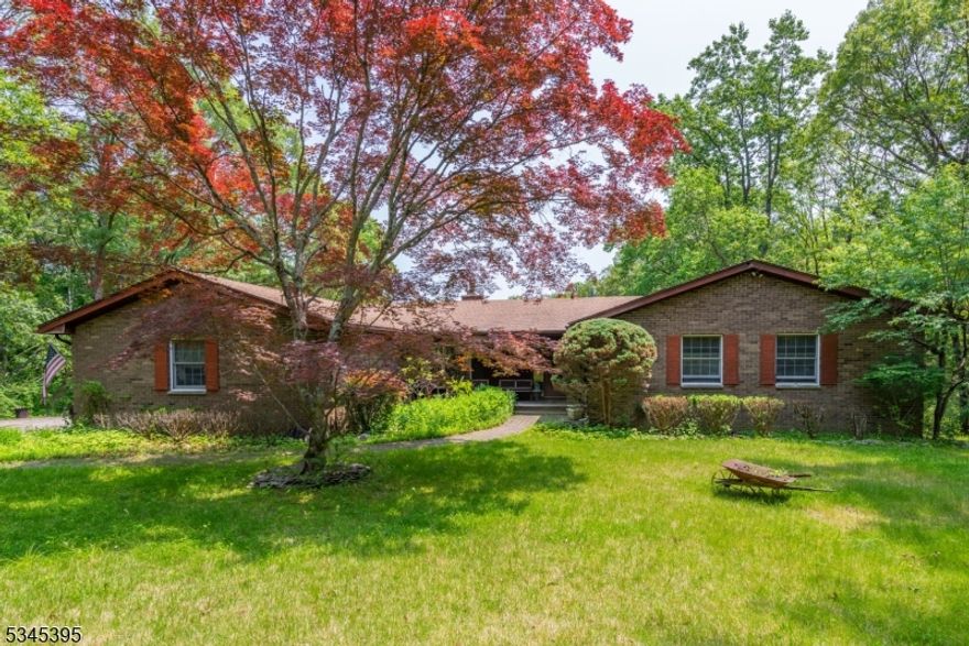 Tucked back from the road and surrounded by nature, this expanded brick ranch offers an incredible opportunity for those seeking space, privacy, and potential. Set on 6.90 acres backing to serene woods, this home is ready to be reimagined. Step inside to find a spacious layout with high ceilings and great flow throughout. The entryway features a soft archway that leads to the large family room with exposed beams and a double-sided brick fireplace shared with the formal dining room. To the left, a bright formal living room with a bay window opens to the main living areas. The oversized eat-in kitchen features a breakfast bar and sliders to a private back deck over looking your serene and private backyard. Each of the four bedrooms is generously sized, including a primary suite with walk-in closet and en suite full bath. A second full bath and beautiful hardwood floors complete the main level. The mudroom connects the 2-car garage, kitchen, side entrance, and stairs to the walk-out basement. Downstairs offers a massive finished space with a built-in bar, large utility/storage room, full bath, laundry, and sliders to the backyard- ideal for entertaining, hobbies, or in law suite conversion. Solid and full of charm, this well-loved home offers great bones, incredible square footage, and peaceful surroundings. Bring your vision and unlock its full potential. UNDERGROUND TANK IS PRESENT. CASH BUYERS - THIS IS A SHORT SALE.