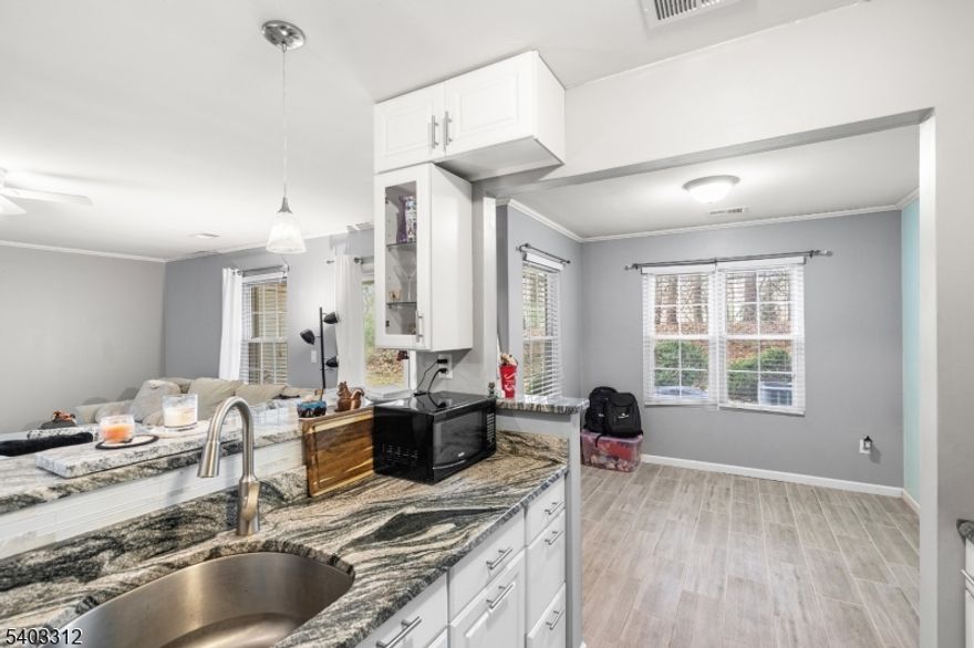 Welcome to this beautifully updated lower-level 2-bedroom, 2-bath condominium offering comfort, style, and low-maintenance living. The home features ceramic wood-look tile flooring throughout and a thoughtfully renovated kitchen with newer cabinetry and granite countertops. The spacious primary bedroom offers a huge closet and private en-suite bath.  Both bathrooms have been updated with newer flooring, vanities, showers, and toilets.    A stackable washer and dryer provide convenience allowing space for a pantry. Additional upgrades include newer double pane noise reducing windows, a hot water heater, and a brand-new HVAC system! This perimeter ground-level unit has an outdoor storage closet plus a private patio overlooking a wooded embankment for added privacy and natural views.Enjoy all the benefits of condo living, including access to community amenities such as a pool and tennis courtswithout the hassle of landscaping or snow removal. Ideally located and move-in ready, this home is the perfect blend of modern updates and easy living.