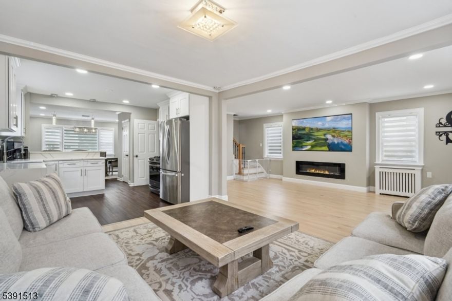 Welcome to this beautifully renovated 3 bedroom, 2.5 bath Colonial, blending timeless charm with modern luxury. Step inside to find brand new hardwood floors flowing seamlessly throughout both levels, creating an inviting and elegant atmosphere. The kitchen is a true showstopper, showcasing waterfall marble countertops, sleek cabinetry, and new high end stainless steel appliances designed for both beauty and functionality. Adjacent, the dining room features a large window overlooking the backyard, filling the space with natural light and creating a warm, inviting atmosphere for everyday meals or entertaining. The spacious living area includes a custom built-in electric fireplace, perfect for cozy evenings or stylish gatherings. A convenient powder room on the main floor adds everyday practicality. The finished basement offers a rec area, full bathroom and kitchenette, ideal for guests, a home office, or extra living space. Upstairs, you'll find three bright bedrooms and an updated full bathroom, plus a large finished attic for ample storage. Enjoy outdoor living on the new covered composite deck, perfect for entertaining or relaxing year round. Just steps from a NYC bus stop, this home is a 5 minute walk to Blue Ribbon Oakview Elementary School and close to parks, shops, and the GSP for easy commuting, & features a driveway with space for up to four cars. Every detail has been thoughtfully updated to offer comfort, style, and convenience- making this home truly move in ready!