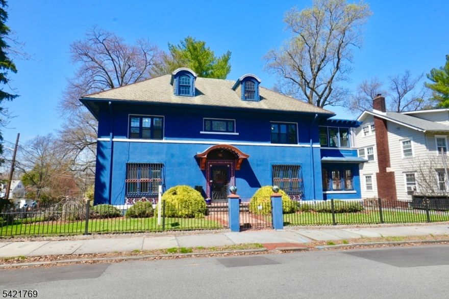 This exquisite Colonial, nestled in the heart of historic Forest Hills, captures timeless elegance with refined architectural details and abundant old-world charm. Built in 1927, this distinguished home welcomes you with a grand foyer that sets the tone for its classic sophistication.   The grand living room, complete with a fireplace, offers a warm and inviting atmosphere perfect for gatherings. A beautifully renovated kitchen features a center island, creating a unique space ideal for both culinary pursuits and entertaining. The formal dining room adds to the home's charm and functionality. Additional highlights include 2 sunroom and a convenient powder room. The residence offers 7 spacious bedrooms, including a luxurious primary suite with a newly renovated bathroom and two closets, along with a total of 4.5 bathrooms. Situated on an oversized corner lot, the property boasts a marvelous backyard and a one-car garage. Located near Branch Brook Park, residents can enjoy stunning cherry blossoms in the spring and expansive green spaces year-round. The nearby light rail station provides easy access to Newark Penn Station, connecting you to NJ Transit and PATH trains for a seamless commute into Manhattan and beyond.