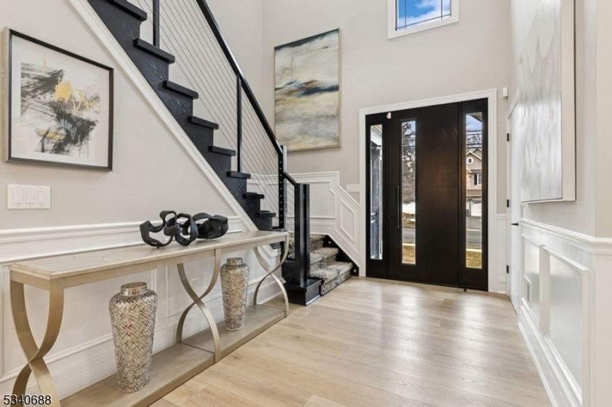 Stunningly renovated Colonial style home offers five bedrooms, four-and-a-half bathrooms, and an attached one-car garage. Situated on a manicured lot with a back yard pool, this home is close to schools, shopping, dining, parks, and the train station to New York City.A wide driveway for extra parking takes you inside to a two-story foyer revealing a magnificent interior perfect for entertaining. Distinctive features include hardwood floors, an open floor plan, elegant crown molding, large windows for abundant natural light, coffered ceilings, and modern luxury finishes throughout. The sleek and stylish chef's kitchen is equipped with quartz counters, custom cabinetry, high-end appliances, and a waterfall countertop island with seating. The open flow continues to the large living room with a coffered ceiling and a gas fireplace adjacent to the banquet-sized dining room ideal for dinner parties. Throw open the sliding glass doors to relax or entertain on the patio surrounding the serene in-ground swimming pool. Completing the main level is a convenient laundry room, a bonus room, and a powder bathroom.The second floor includes the primary bedroom suite with two walk-in closets, and a luxurious en suite bathroom with a pedestal tub and an oversized glass shower. There are four additional bedrooms, one with an en suite bathroom, and a hallway bathroom. The finished basement offers a huge recreation room, a glass-enclosed exercise room, a full bathroom, and plenty of storage.