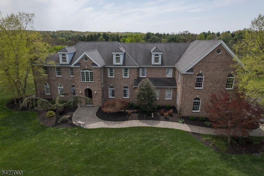 Welcome to this beautifully designed 2-story home located in a Blue-Ribbon school district in Montgomery Twp NJ, minutes from shopping and downtown Princeton. Built in 2007, the 6843 sqft home sits on a quiet cul-de-sac on six acres. A grand 2 story foyer welcomes you with a soaring 23 ft beamed ceiling which sets the tone for the spacious 1st floor, offering abundant living & entertaining spaces. The extra-large kitchen serves as the heart of the home, featuring granite countertops, an oversized island, and eat in kitchen with an additional staircase. Just off the kitchen are two walk-in pantries, a sunroom/breakfast room leading out to a full stone patio, a butler's pantry, and a large 1st-floor laundry/craft room. You'll also find a home office/5th bedroom, a full bath, large sunken family room with a tray ceiling and fireplace, and a formal dining room. Upstairs, you'll find the Primary Suite with a sitting area and fireplace, 2 Junior Suites with full bathsand walk in closets & an additional bedroom, offering ample space and tons of storage. For entertaining there is a 1100 sq ft great room with beamed cathedral ceilings. Additional highlights include a 4-car garage, large driveway, extensive custom moldings, paneling and quality finishes throughout. The unfinished walkout 3500 sqft basement provides generous storage & possibilities for future expansion. It's the perfect home for large gatherings. Don't miss this exceptional opportunity in a prime Montgomery location!