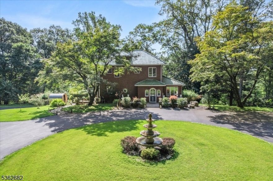 Welcome to this beautiful custom Mediterranean-style home in the desirable Backhus Estates, set on just over 5 acres of lush, private property. Originally built in 1937, this home is filled with charm and character you won't find anywhere else. Enter through the arched foyer into the spectacular living room with custom hand-carved mahogany moldings, ornamental trim, high ceilings, original lighting and a wood burning fireplace. An arched doorway leads to the conservatory, surrounded by custom bookcases, and a cozy library just off the living room. The large formal dining room with a french door that opens to the patio and picturesque landscapes of surrounding area. The eat-in kitchen offers plenty of space and direct access outdoors for easy indoor-outdoor living. Upstairs you'll find the primary bedroom with its own bath, along with three additional bedrooms, an office, and another full bath. The finished walk-out ground level adds additional living space, complete with a full bath and kitchen perfect for guests, a studio, or an in-law suite. Outside, enjoy oversized circular driveway, mature trees, tranquil surroundings that make this property feel like your own private retreat. New solar panels with battery back up and two EV charging stations. This unique estate blends timeless craftsmanship with endless potential. You are not only buying a home but buying a piece of history.