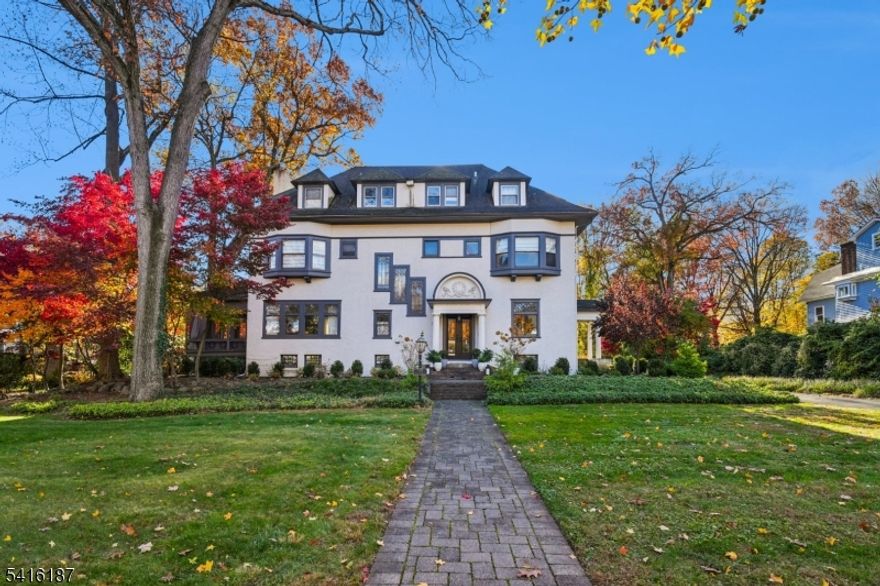 Welcome to this magnificent Colonial Revival estate on nearly three-quarters of an acre, just 0.7 miles to South Orange's Mountain Station. This stately 7-bedroom, 4.1-bath residence seamlessly blends historic grandeur with modern convenience following a comprehensive 2014 renovation. The moment you arrive, the home's impressive facade and presence set the tone. Inside, soaring ceilings and oversized windows flood the gracious rooms with natural light. The formal living room features the original fireplace and opens to a sun porch overlooking a stone patio that leads to the expansive property perfect for morning coffee, afternoon naps and entertaining. Everyday living shines in the chef's kitchen, fully renovated in 2014, featuring a center island and separate seating/dining area with built-in banquette. Multiple gathering spaces across three finished floors provide room for everyone, including a second-floor library with its own fireplace ideal for a home office or quiet retreat. Seven bedrooms offer flexibility and plenty of room for guests or home offices. The primary suite features two generous walk-in closets and en suite, renovated bath. Beautiful period details like leaded windows add character throughout. The property itself is a treasure .73 acres of mature landscaping provides privacy and room to roam, yet you're less than a mile to NYC-direct trains. Photos of the beautiful interior will be posted Thursday, March 12!