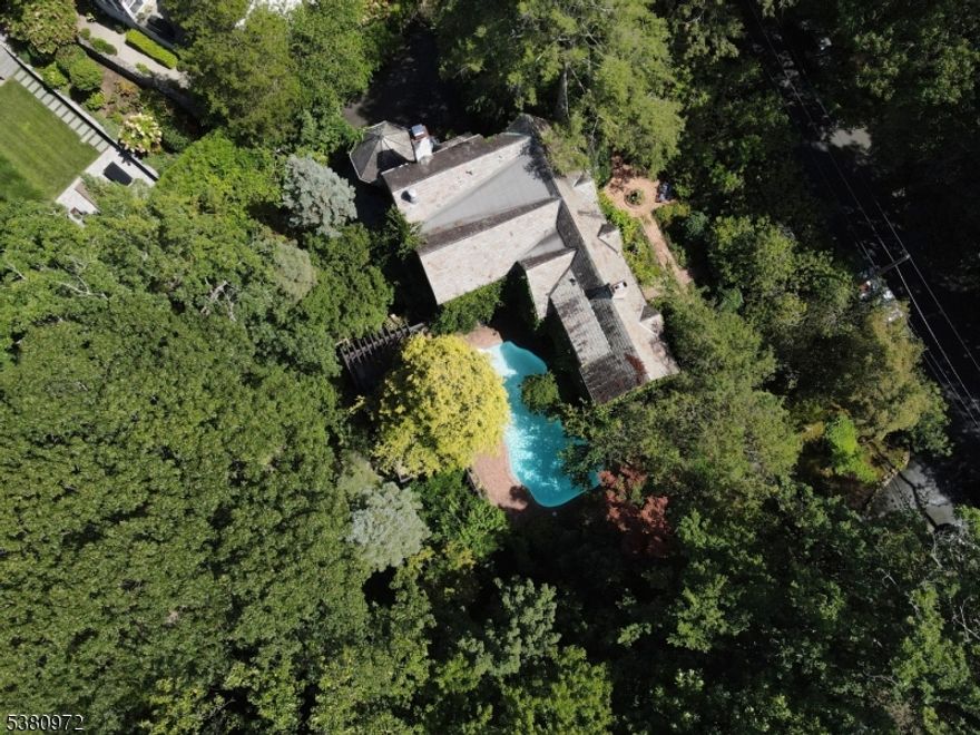 A wonderful opportunity for those seeking a personal and private sanctuary filled with koi ponds, waterfalls and established gardens. this one-of -a-kind 1930 home has 4 bedrooms and 3.5 baths, and is set on just over an acre of lush landscaped property bordering a bird sanctuary offering incredible tranquility in a bucolic setting.Spacious living room with gas fireplace,elegant formal dining, cozy den/bedroom with a half bath,kitchen with ample white cabinetry with recessed lighting and stainless steel appliances,direct flow to breakfast area with custom gas fireplace sun-drenched family room with second fireplace, stunning octagonal screened-in porch with vaulted ceiling, the second floor is host to primary suite with large bedroom, multiple closets and luxurious adjoining full bath with double vanity, soaking tub and glass-enclosed walk-in shower. two more bedrooms each boast their own en-suite bath, with the largest bedroom also featuring a walk-in closet. Enjoy exploring in the park-like grounds that allow you to feel like you are in another world with multiple pathways,ponds,waterfalls and more. the sparkling in ground pool is also perfect for cooling off in total privacy, with a brick patio and ground-level deck with pergola for relaxing and entertaining. A unique gem in an excellent location in one of New Jersey;s most desirable towns