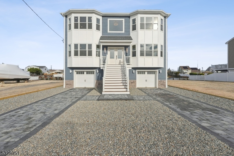 DREAM NEW CONSTRUCTION WATERFRONT home in Manahawkin! Boasting over 3,050 sqft w. 50 FT bulkhead to park your boat or jetskis, this PRIME LOCATION is minutes to the open bay w. no bridges to pass under. The chef's kitchen is equipped w. beautiful oak custom cabinets, large center island, premium SS appliances, quartz counters & backsplash. The grand family room is a true showstopper w. 2 story glass foyer, gas fireplace & access to expansive 1st floor deck. Premium oak hardwood floors throughout, designer light fixtures & premium moldings compliment each space. Enjoy water views & coffee off your master private deck. No need to compromise luxury living w. a large master walk-in closet & luxurious spa master bath w. soaking tub. Large size guest bedrooms feature jack & jill bath, and the main floor ensuite is perfect for generational guests. Outside, find 1,000 sqft of exterior decking across 3 floors, including a custom 2-story spiral staircase up to the fiberglass rooftop deck w. bay/bridge views. The home has an oversized 2-car garage & paver driveway leading up to the grand entrance. Behind the walls, this home is architecturally over-engineered to withstand the elements. This is not your cookie cutter new build! Don't miss the opportunity to own this exceptional new construction home and embrace waterfront living. Custom Design by award winning Samaan Design Group, this home is surely a showstopper that will be the centerpiece of many memories to come!