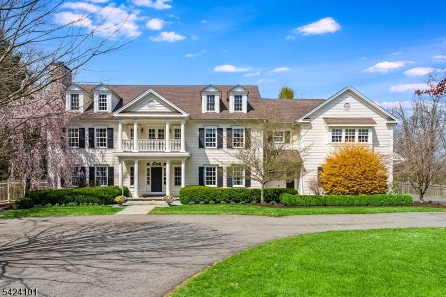 This Georgian colonial home is set on over three acres on one of Mendham's most desirable streets. The home is surrounded by English gardens with bluestone and pea stone walkways and patios. The interior is defined by hardwood floors and elegant millwork, including coffered ceilings and decorative moldings. In the eat-in kitchen, a grand granite center island and breakfast bar serve as the room's focal point. The space is equipped for high capacity cooking with a six burner Viking stove top, a double oven and two dishwashers. This area flows directly into a family room with a gas fireplace, custom shelving and cabinetry and 2 large window seats. Doorways in the kitchen and family room open to a rear patio and herb garden. The ground floor also includes a formal living room with fireplace, dining room, laundry room, and office with its own private outdoor access. The upper floor consists of five bedrooms, all featuring high ceilings and unique details like built-in windows or nooks. Each bedroom has en-suite bathrooms and generous closets/storage. The primary suite is a distinct wing of the house featuring an entry foyer, a bedroom with a fireplace, two walk-in closets, and a private office fitted with high-end cabinetry. The master bath is designed with a curved barrel ceiling and features a soaking tub, large shower, two separate vanities and WC. A rec room, gym, full bath, mini kitchen and ample storage are located on the lower level.