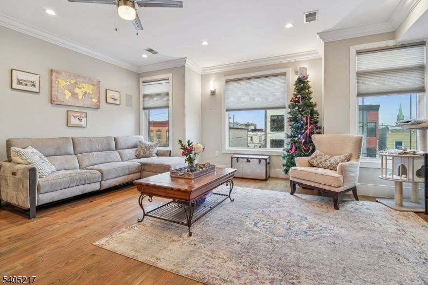 Don't miss the Private Roof Top Deck!! Move right into this stunning condo with low taxes and minimal HOA! Featuring three bedrooms, two baths, parking for two cars, wide crown molding, hardwood floors, custom kitchen and an island with quartz countertops, stainless steel appliances and a wine cooler. Gorgeous spa-like baths with multi jets and shower sprays. Pella transom windows for generous natural light, tankless hot water system, central vacuum, camera security and video intercom door bell. Private 750 square foot rooftop terrace with sound speakers, electric, water and gas line increasing your outdoor enjoyment and eastern NYC view and mountain vistas to the west. Located in JC Heights on a residential city street and low HOA. Conveniently close to NYC transportation, bus to Journal Square PATH or a stroll through the park to the Light Rail Station. Two spots for parking are an added bonus. *** NEW PRICE***